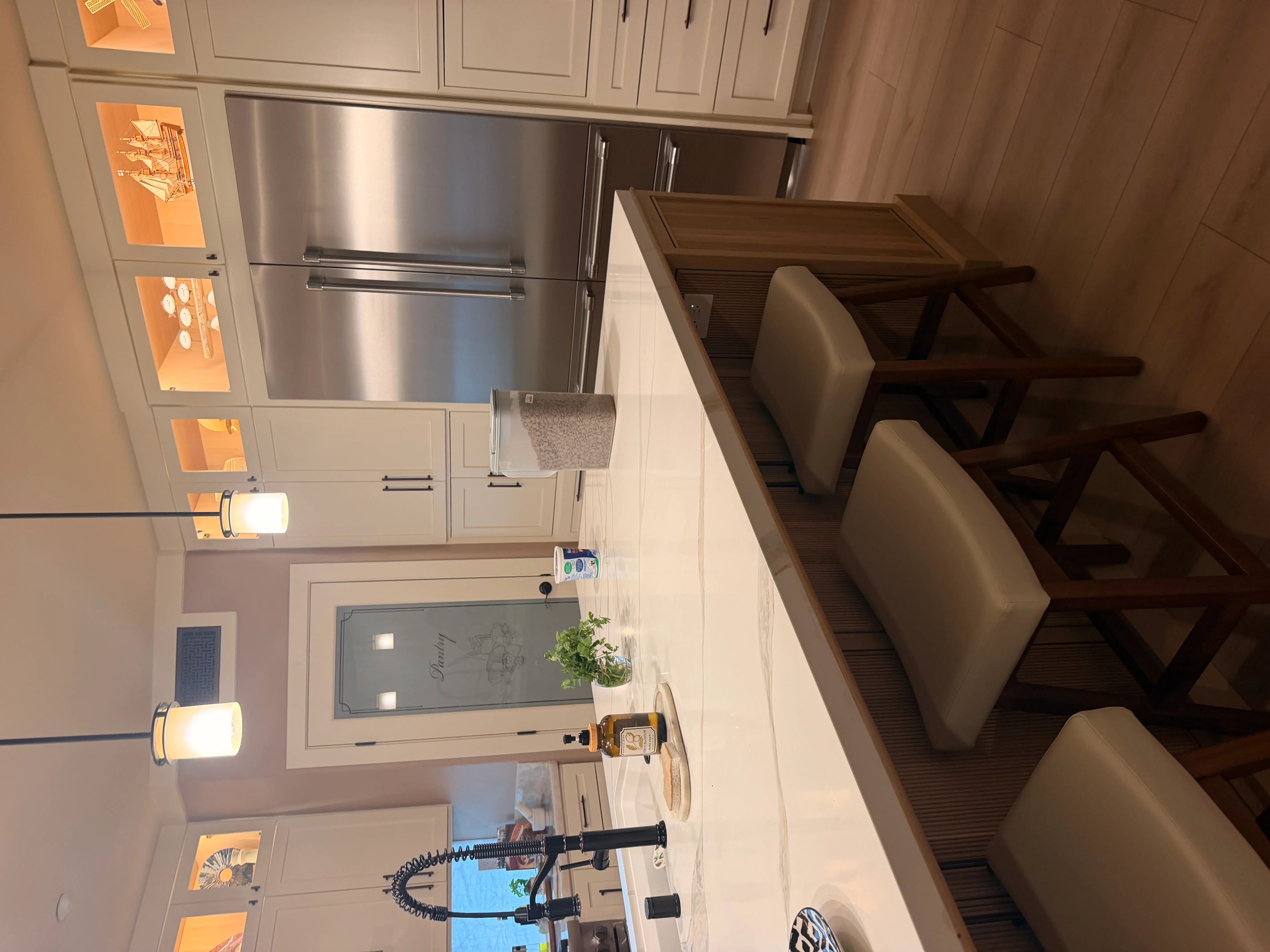Kitchen with cream cabinetry, stainless steel refrigerator, and recessed lighting