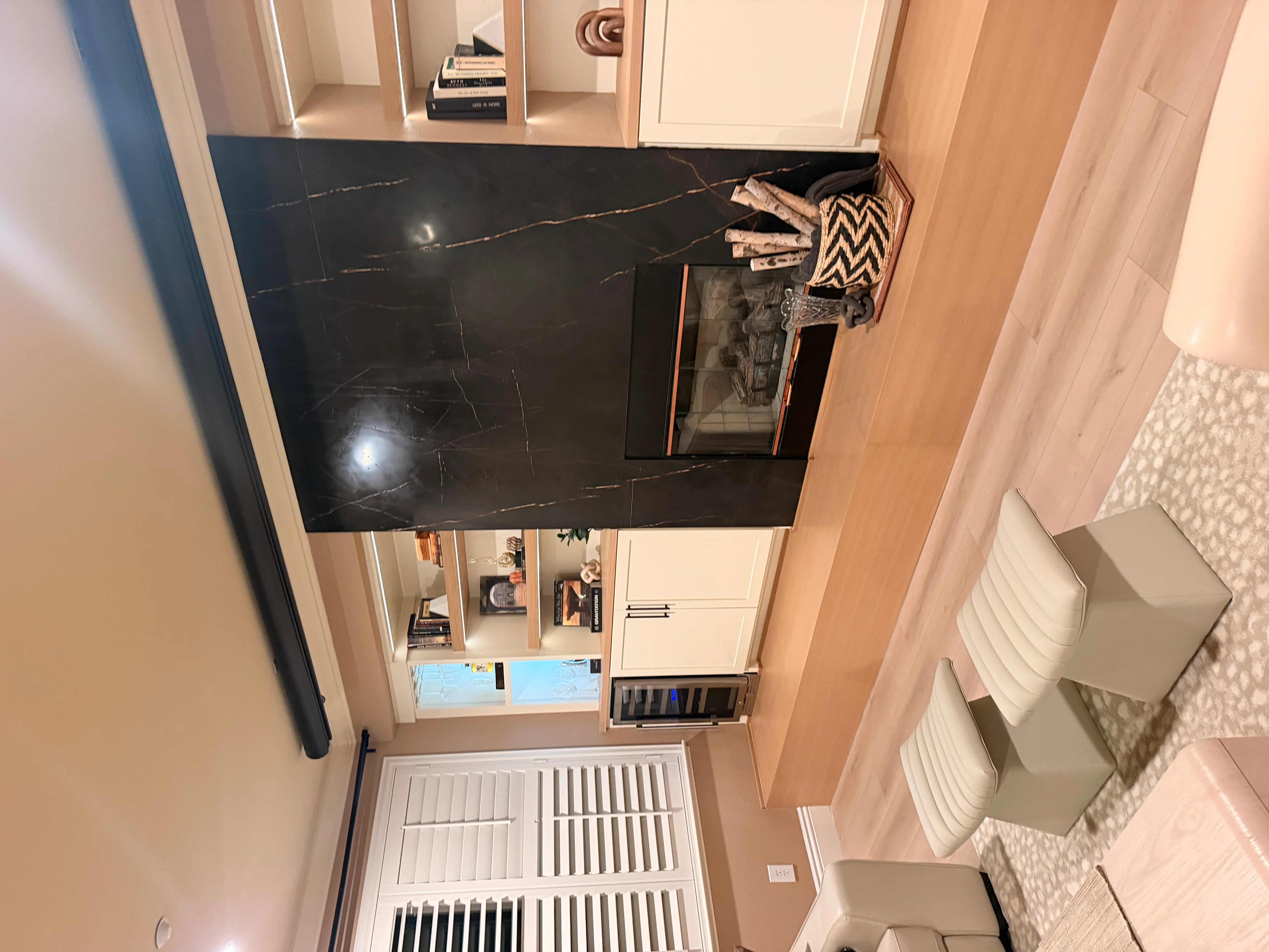 Black marble tile floor with gold veining, white cabinetry, and bathroom fixtures in renovated space