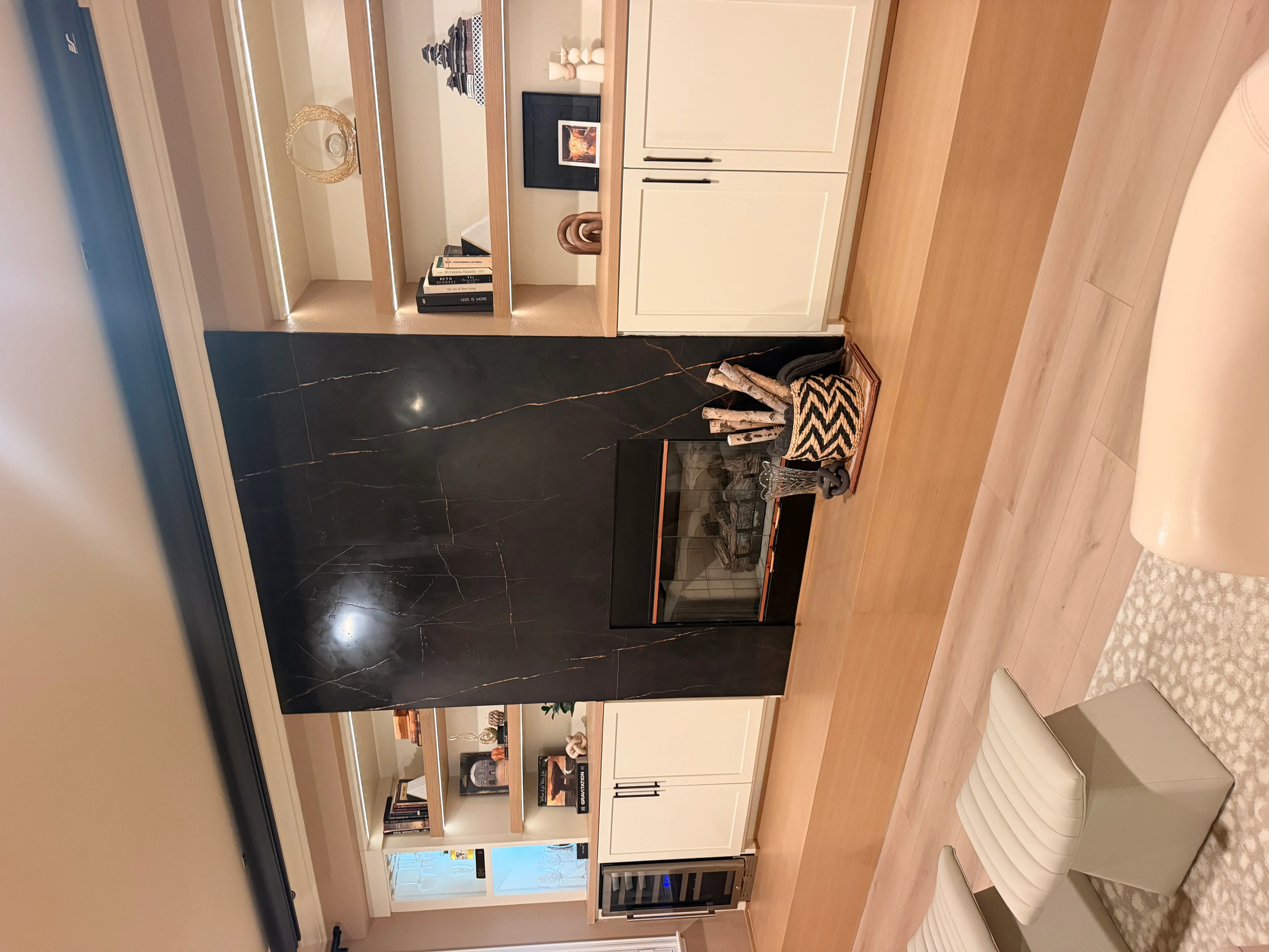 Black marble countertops with gold veining, cream cabinetry, and integrated kitchen appliances