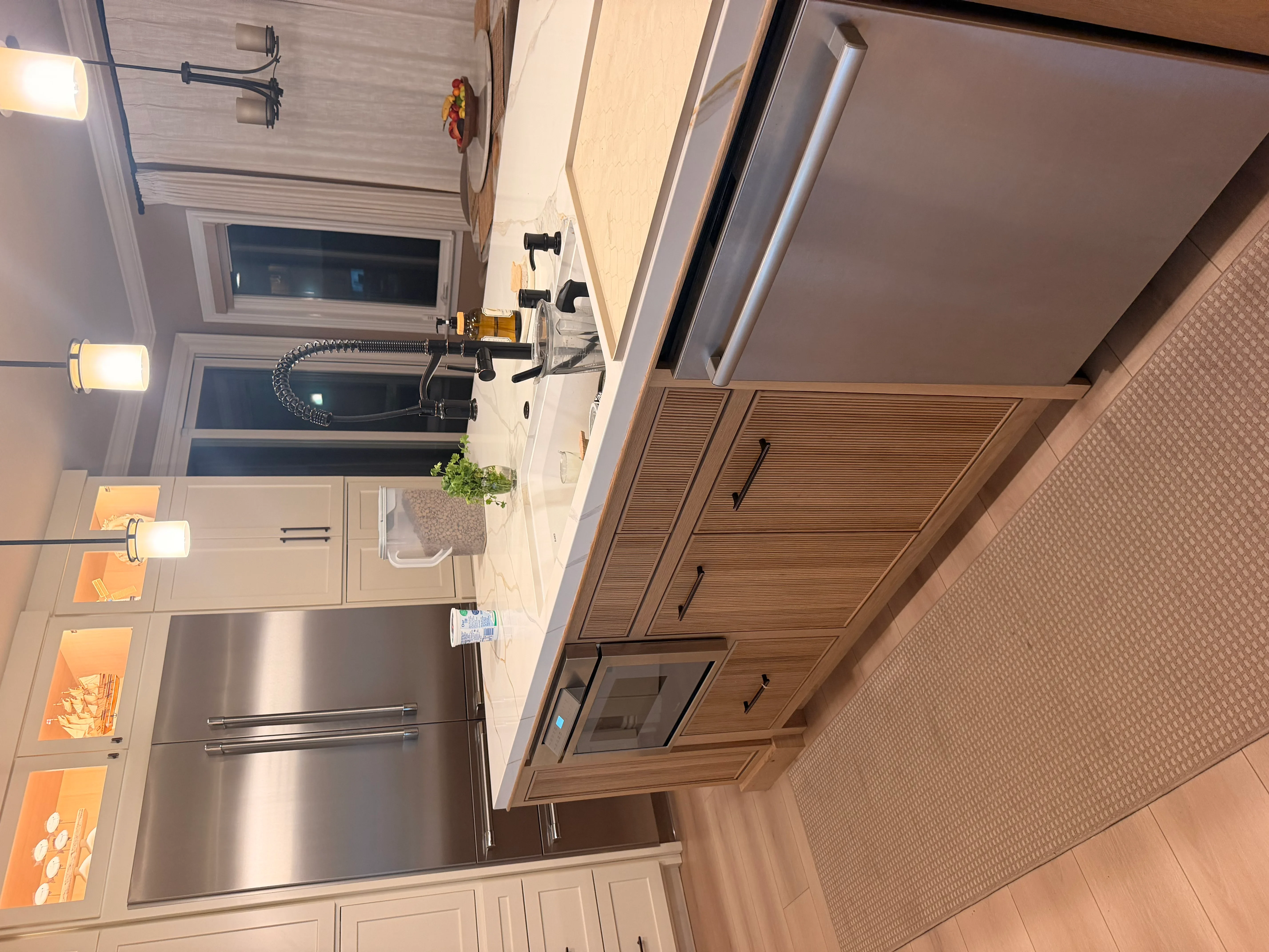 Kitchen with wood cabinetry, stainless steel appliances, white subway tile, and recessed lighting